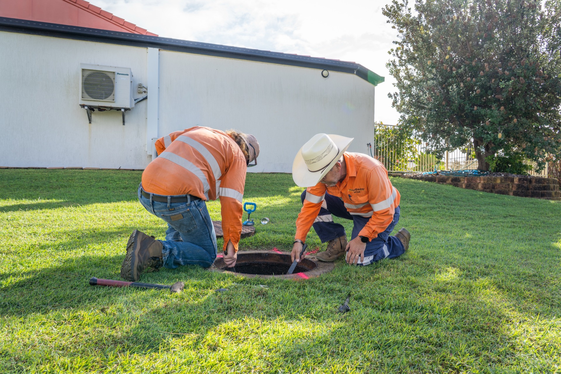 GeoRadar crew working at an open access pit beside a building
